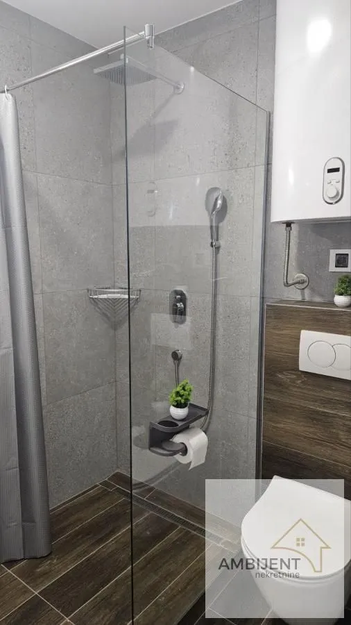 Moderno opremljeno kupatilo sa tuš kabinom i wc šoljom.