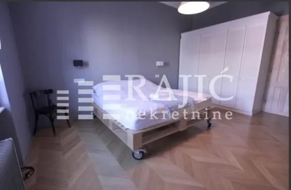 Bedroom with a double bed, large wardrobe, and wooden flooring.