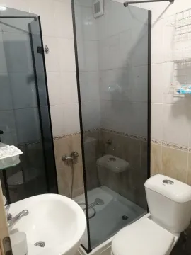 Bathroom with a shower cabin, washbasin, and toilet. - image 8