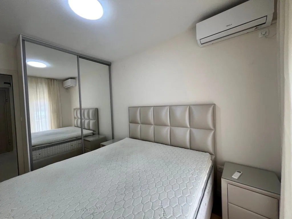 Furnished bedroom with a double bed, wardrobe, and air conditioning.