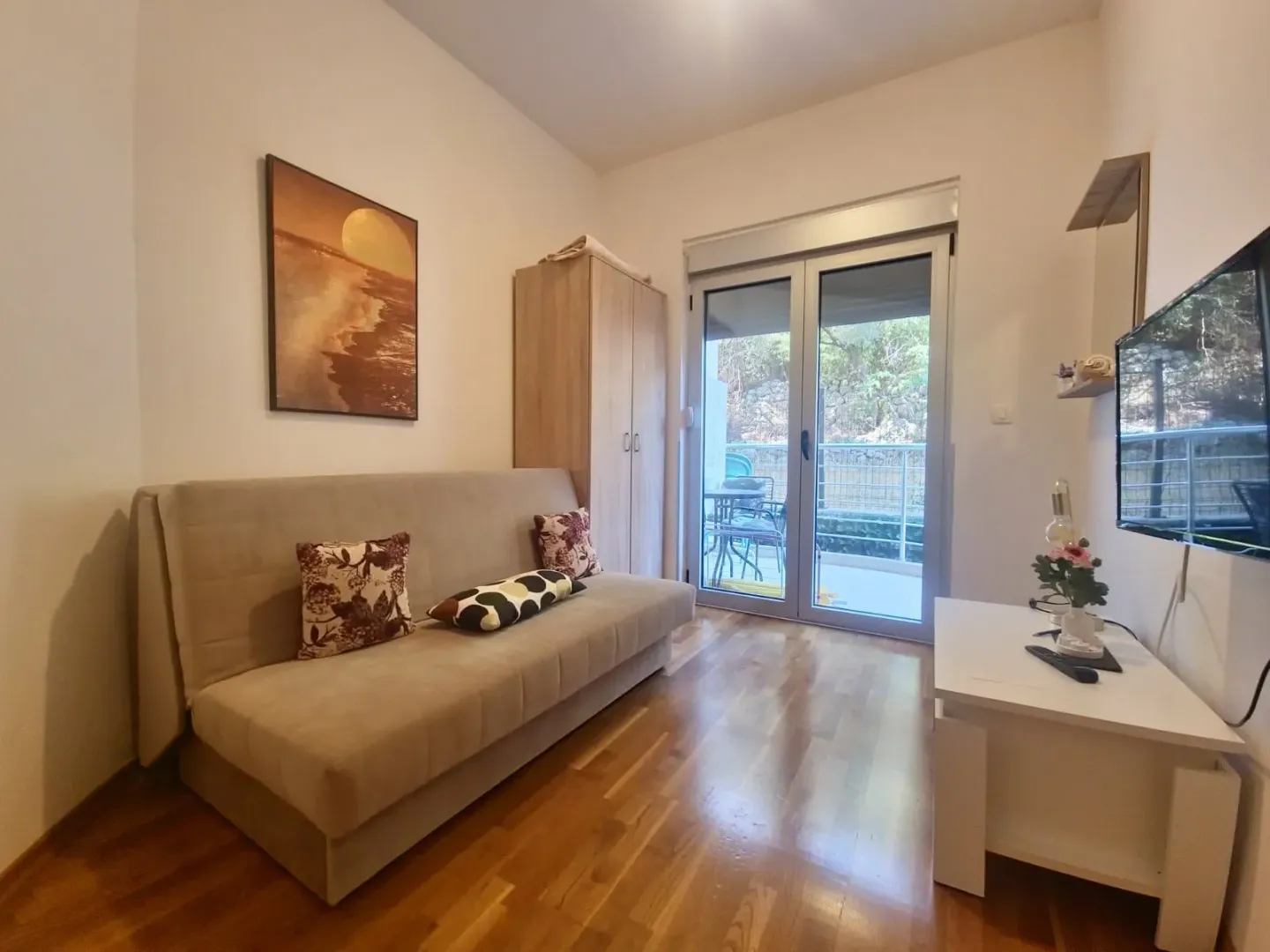 Living room with sofa, TV and access to the terrace.