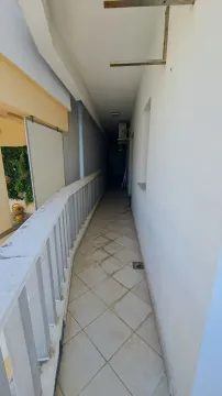 Dugačak natkriveni balkonski hodnik sa keramičkim pločicama i ogradom. - image 2