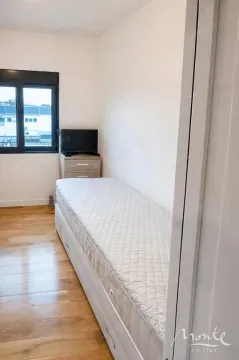 Small bedroom with a bed and a small TV. - image 7