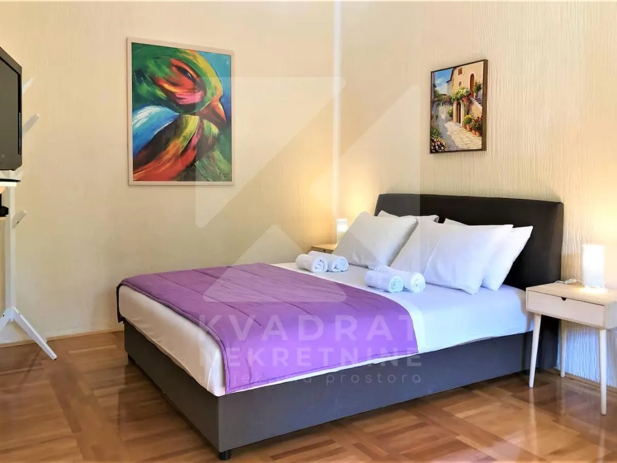 Furnished bedroom with a double bed and paintings on the wall.