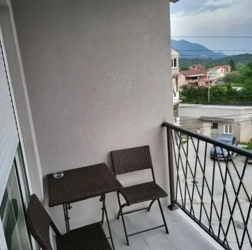 Small covered balcony space with a table and chairs and a view of the surroundings. - image 8