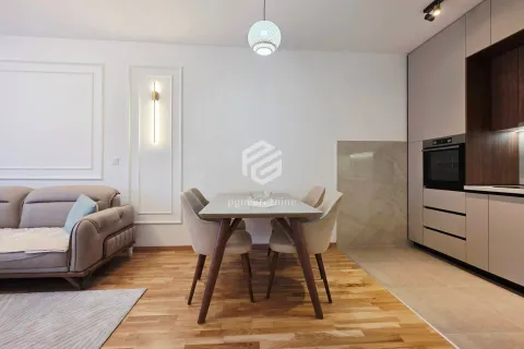 Living room with a dining table and kitchen in the background. - image 13