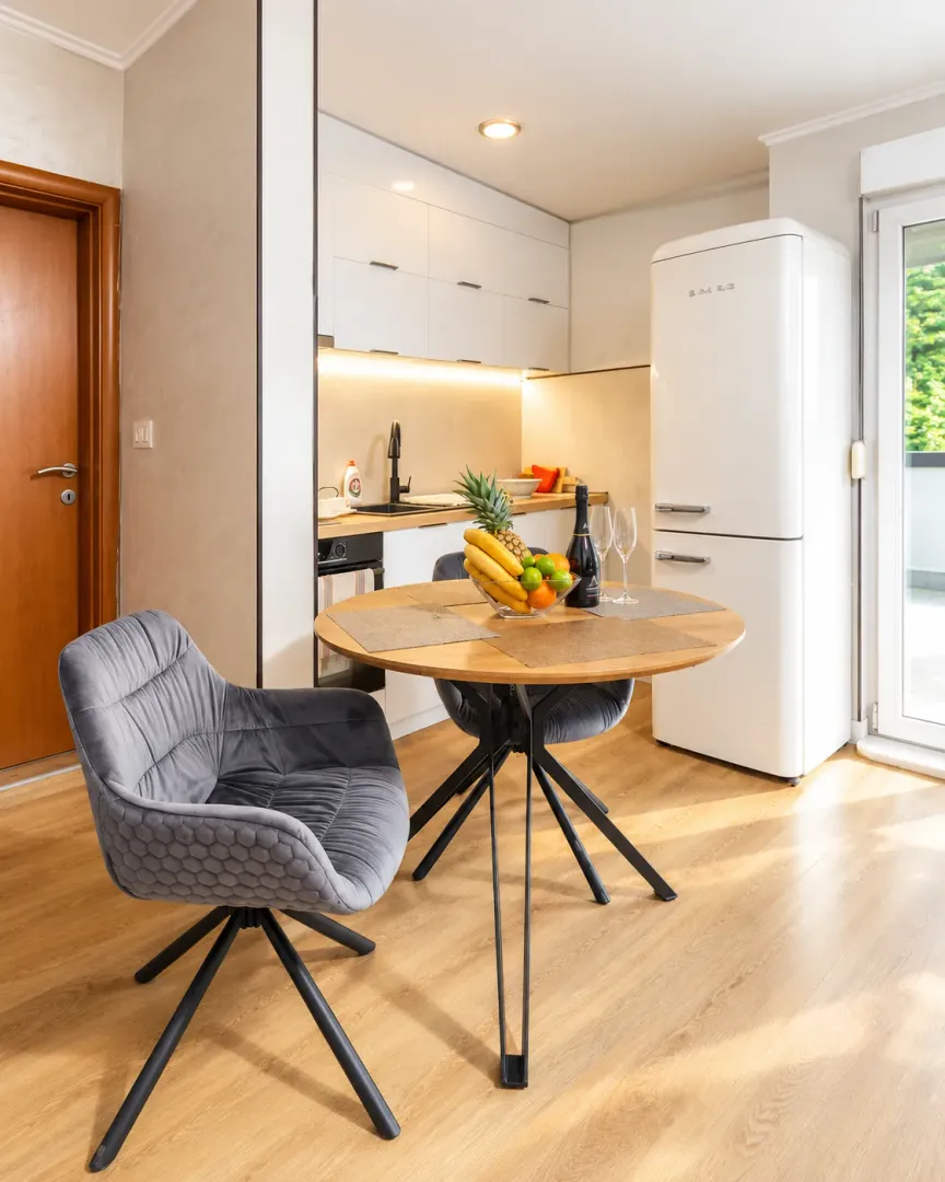 Modern kitchen with a dining table and a white refrigerator.