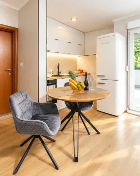 Modern kitchen with a dining table and a white refrigerator. - image 4