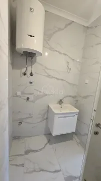 Kupatilo obloženo keramičkim pločicama sa umivaonikom i bojlerom. - image 8