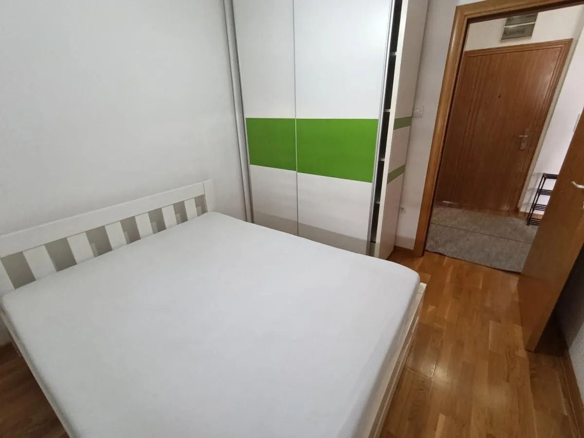 Nameštena spavaća soba sa bračnim krevetom i garderoberom.
