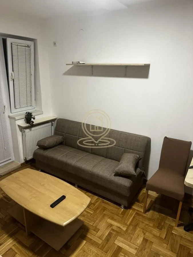 Living room with a sofa, coffee table, and wooden flooring.