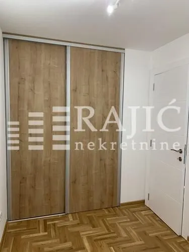 View of a built-in wardrobe with a wood finish in the room.