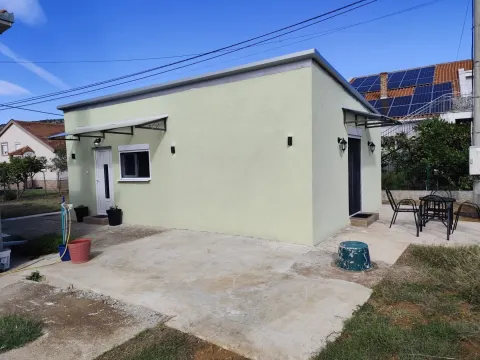Pogled na eksterijer prizemne kuće sa uređenim dvorištem. - image 13