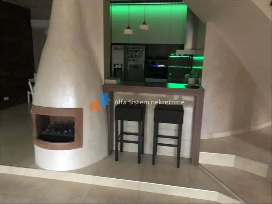 Living room with a fireplace and a breakfast bar separating the kitchen area.