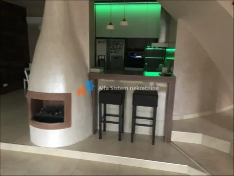 Living room with a fireplace and a breakfast bar separating the kitchen area. - image 24