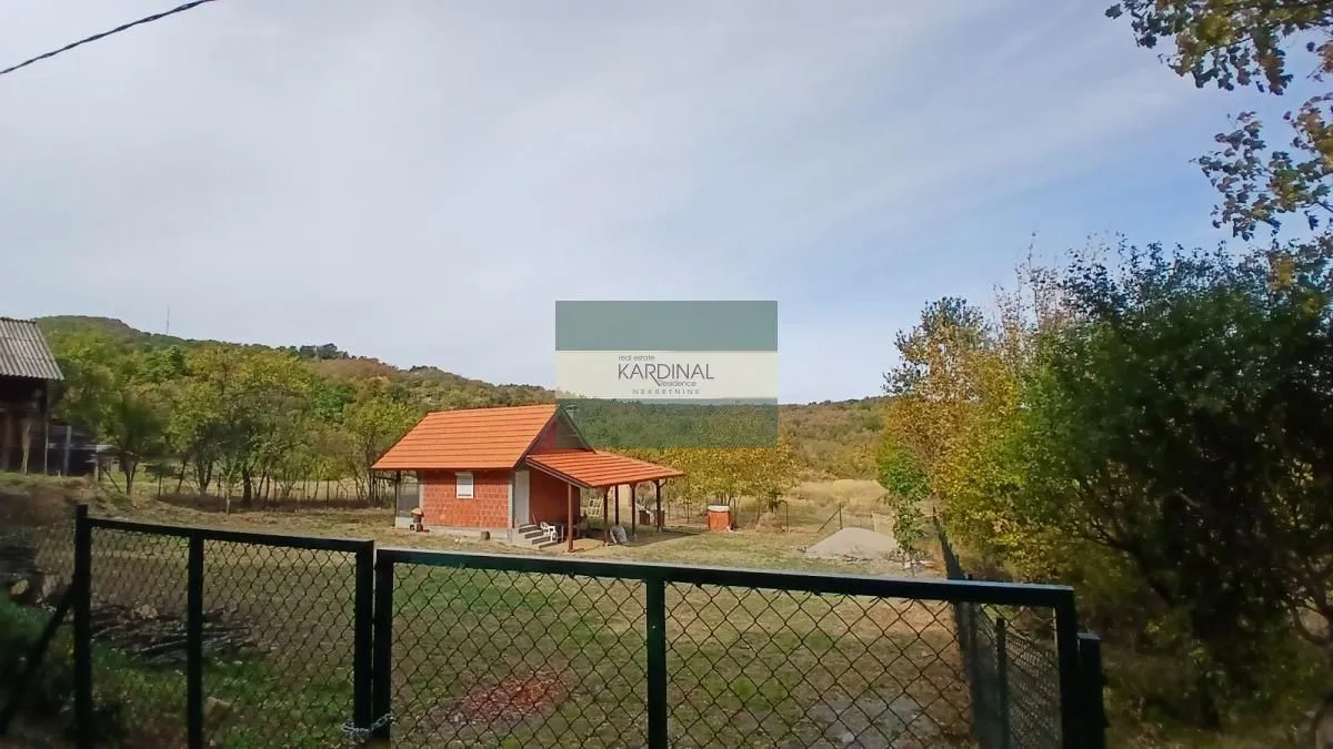 Pogled na manju kuću sa placem i ogradom.