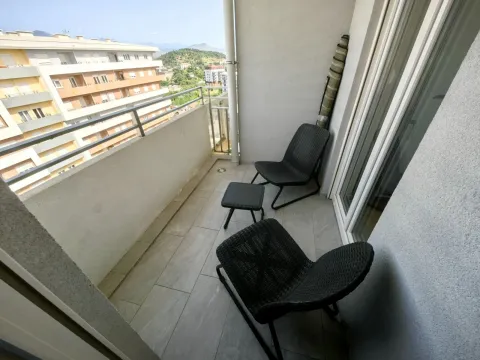 Manji namješteni balkon sa stolicama i pogledom na okolne zgrade i prirodu. - image 17