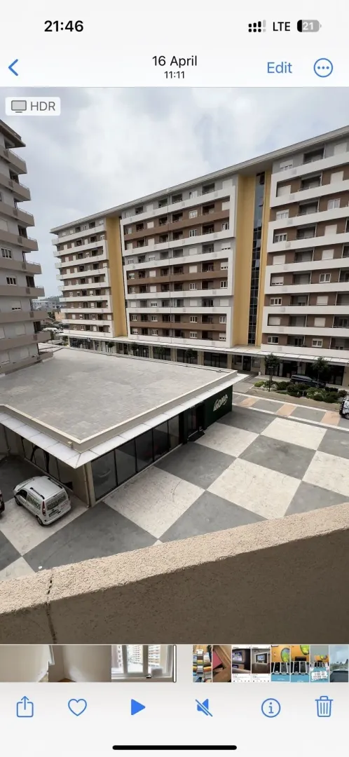 Pogled sa terase na popločano dvorište i višespratne stambene zgrade.