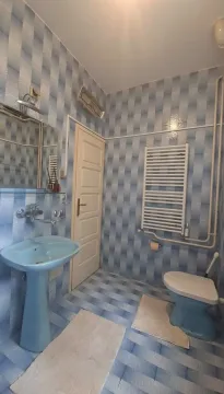 Manje kupatilo sa plavim sanitarijama i pločicama u tonovima plave boje. - image 8
