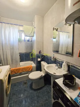 Compact bathroom with a bathtub, washbasin, toilet, and washing machine. - image 2