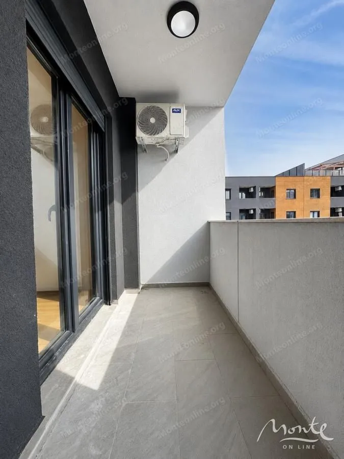 Natkriveni balkon sa pločicama na podu i spoljnom jedinicom klima uređaja.