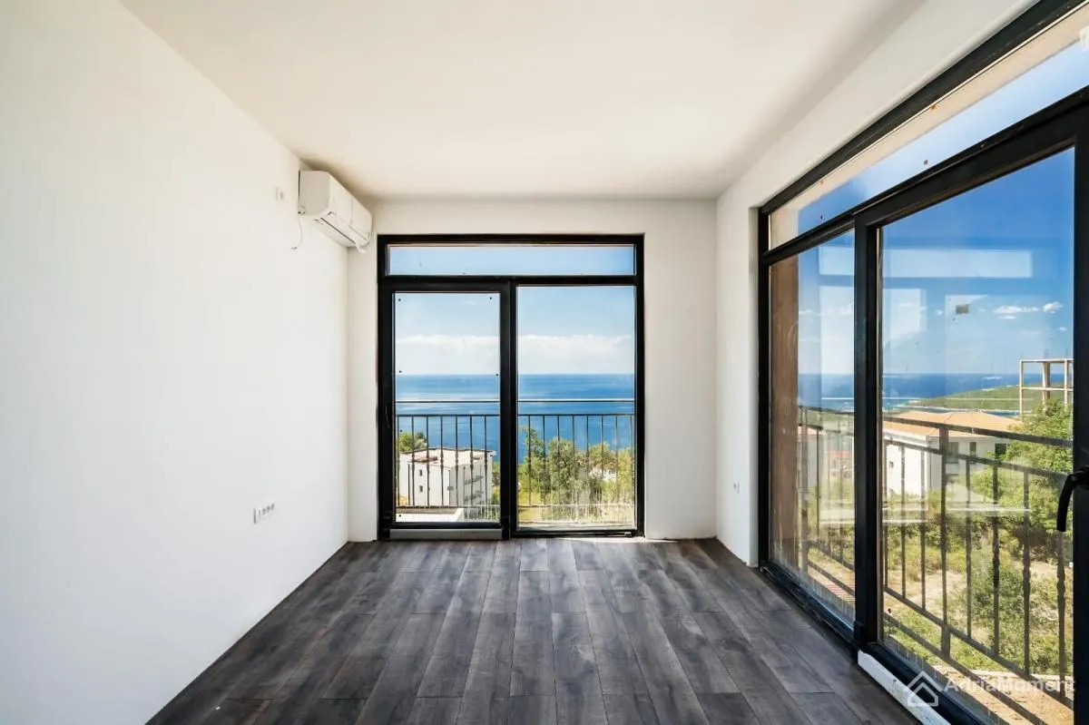 Empty room with large glass surfaces and sea view.