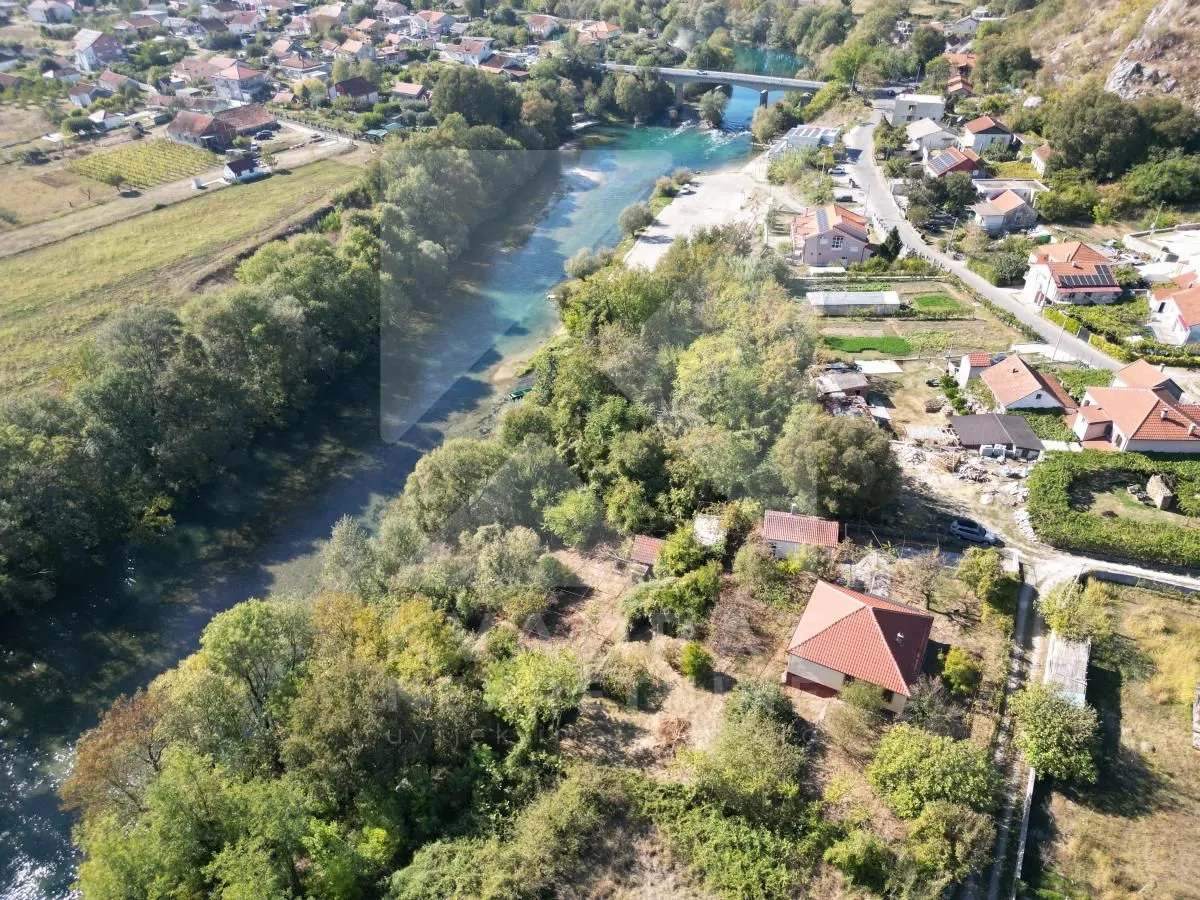 Pogled iz vazduha na imanje u prirodi u blizini rijeke i naselja.