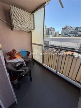 Natkriveni balkoni sa garniturom za sedenje i pogledom na grad. - image 2
