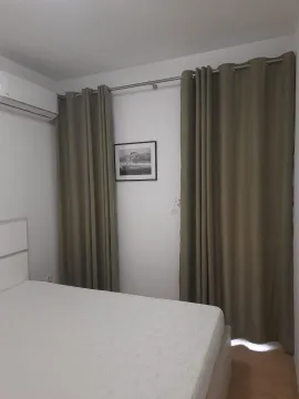 Bedroom with a double bed, air conditioning, and curtains on the windows. - image 2