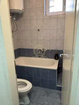 Smaller bathroom with a bathtub, toilet, and water heater. - image 6