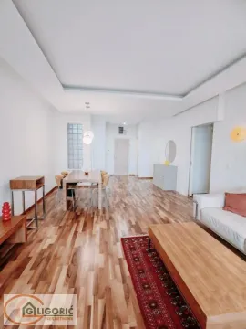 Spacious living room with a dining area and parquet flooring. - image 17