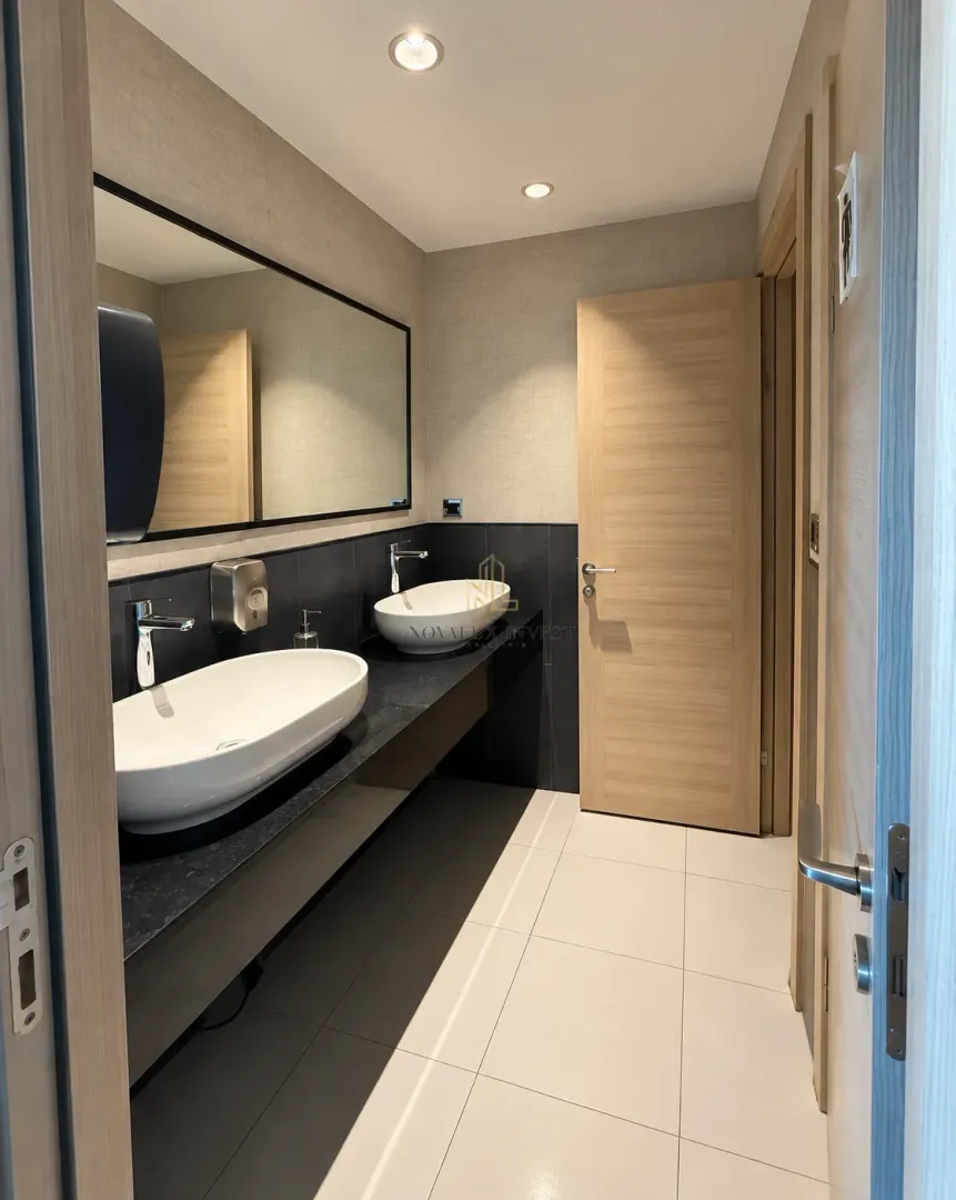 Modern bathroom with double sinks and a large mirror.