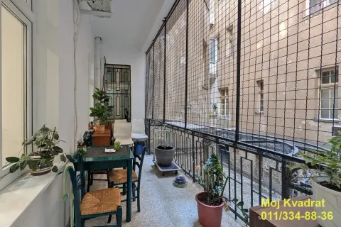 Dugačak zastakljeni balkon sa garniturom za sedenje i ukrasnim biljkama. - image 14