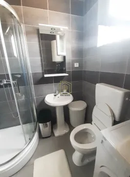 Compact bathroom with a shower cabin, washbasin, toilet, and mirror. - image 6