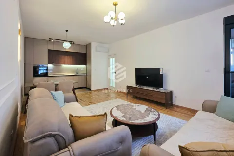 Spacious living room with a sofa set, TV, and kitchen in the background. - image 14