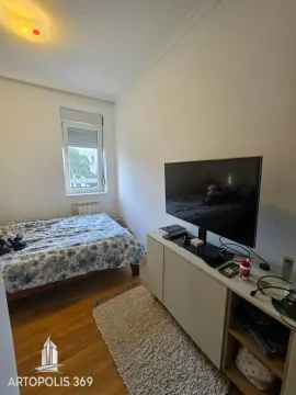 Manja spavaća soba sa krevetom, TV-om i komodom. - image 12