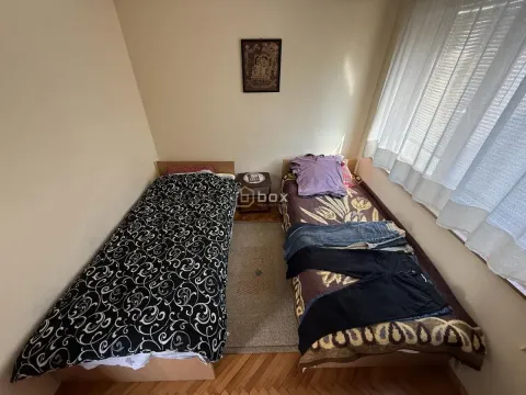 Spavaća soba sa dva kreveta i prozorom. - image 10