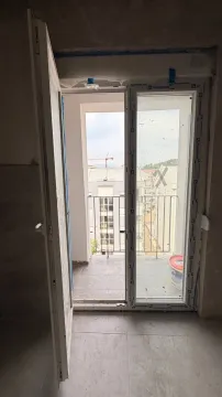 Pogled kroz balkonska vrata na terasu i okolne zgrade. - image 6