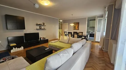 Prostrana dnevna soba sa garniturom, televizorom i trpezarijom u pozadini. - image 5