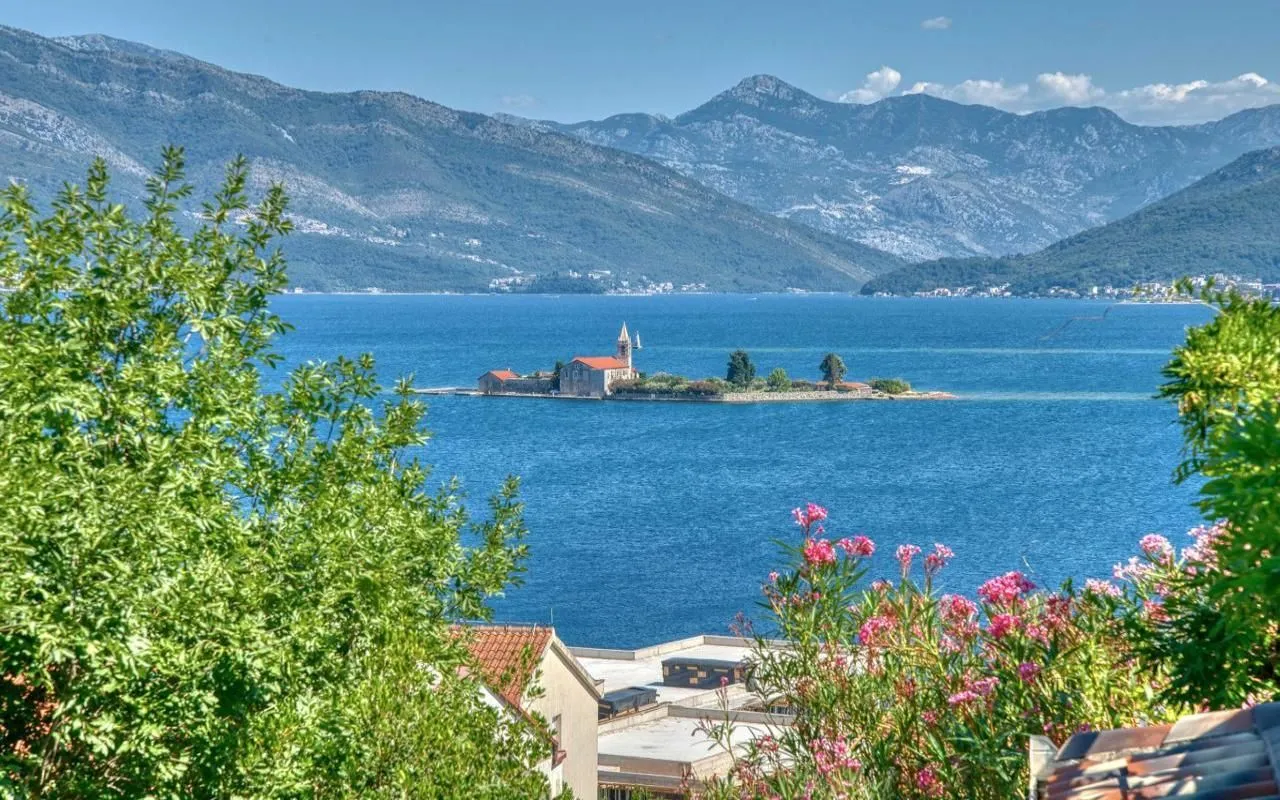 Pogled na more i ostrvo sa ostrvskim manastirom okružen planinama.