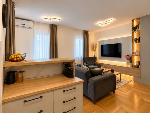 Modern living room connected to the kitchen, equipped with a sofa and TV. - image 15