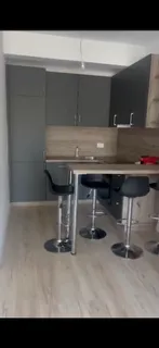Moderna kuhinja sa tamnim elementima, šankom i barskim stolicama. - image 4