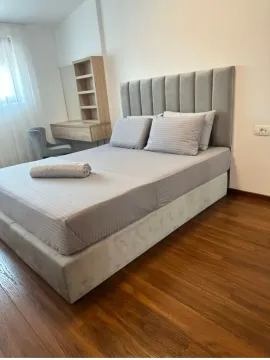 Furnished bedroom with a double bed and wooden flooring. - image 10