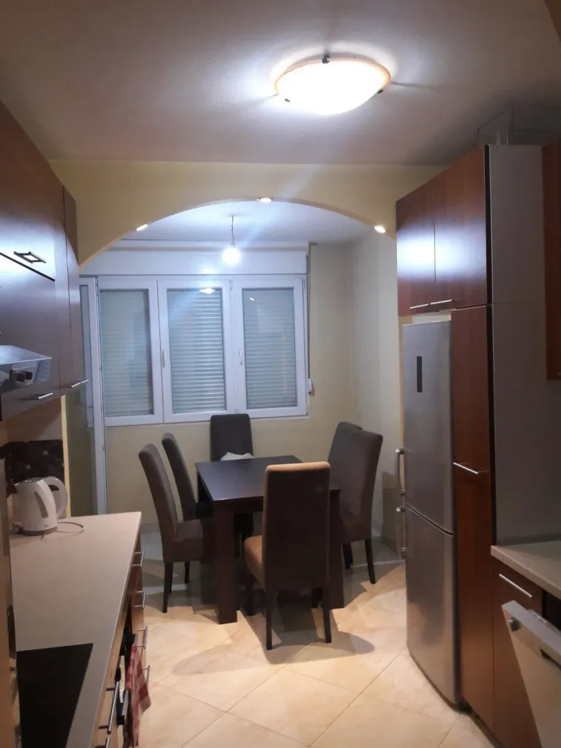 A kitchen with a dining table and wooden cabinets.