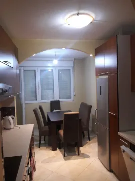 A kitchen with a dining table and wooden cabinets. - image 3