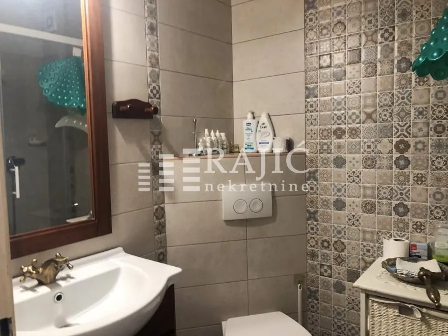 A well-equipped bathroom with a washbasin and decorative tiles.