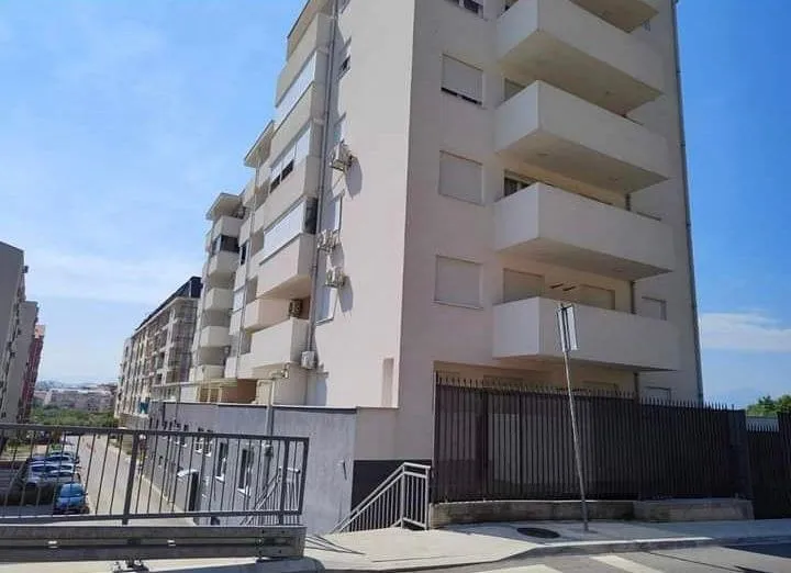 Exterior view of a residential building with balconies and surrounding road.