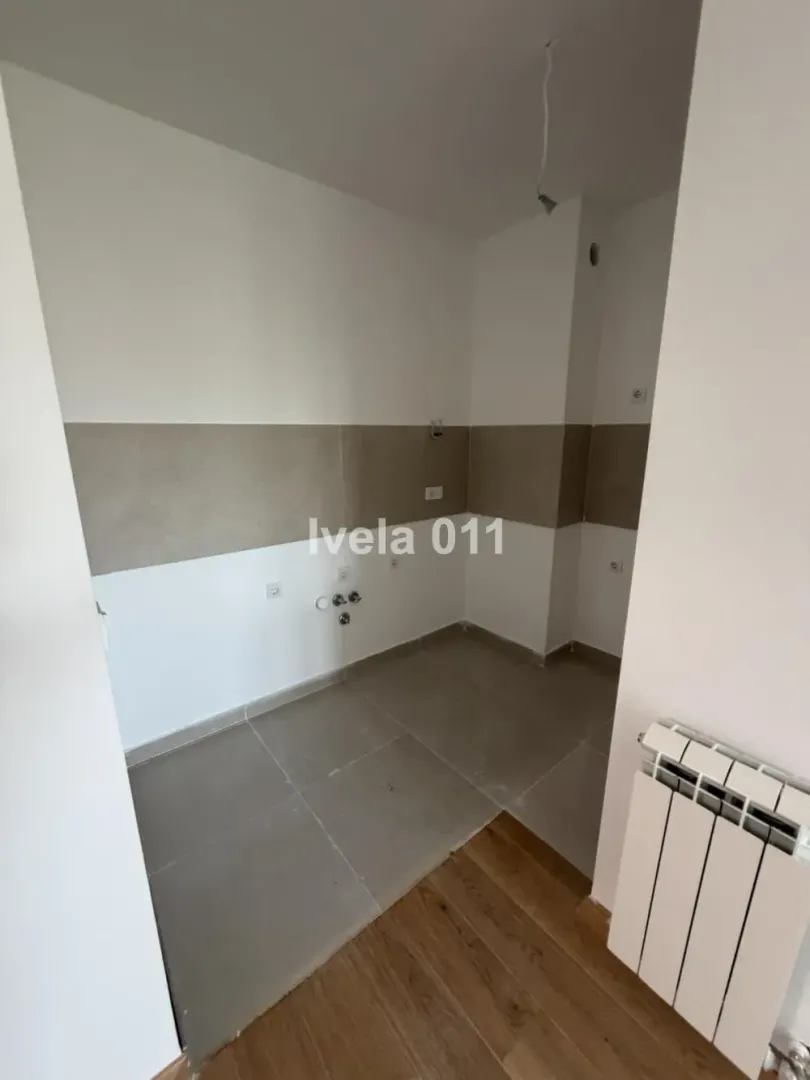 Nenamešten deo kuhinje sa keramičkim pločicama i priključcima za instalacije.