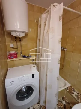 Bathroom with a bathtub, shower curtain, water heater, and washing machine. - image 8