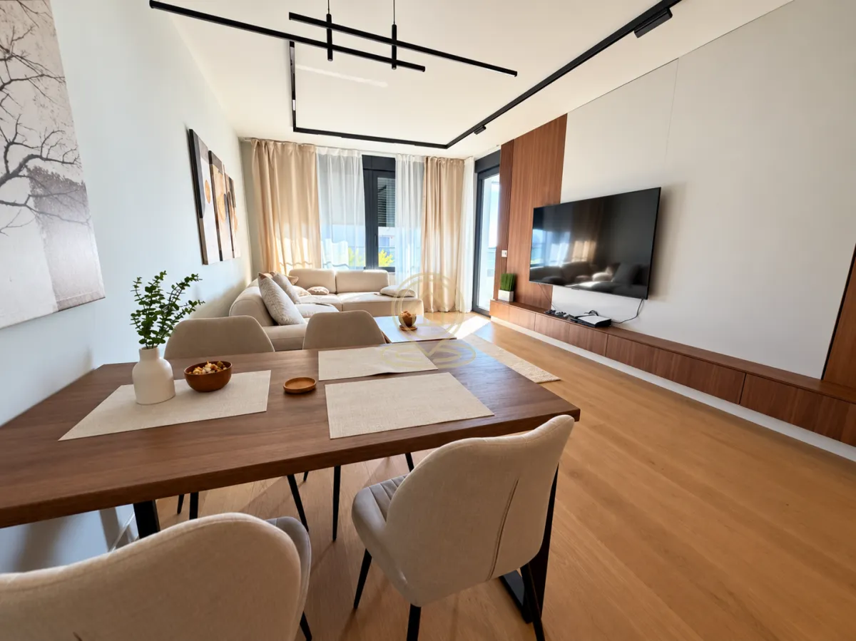 Modern living room with a dining area and a TV unit.